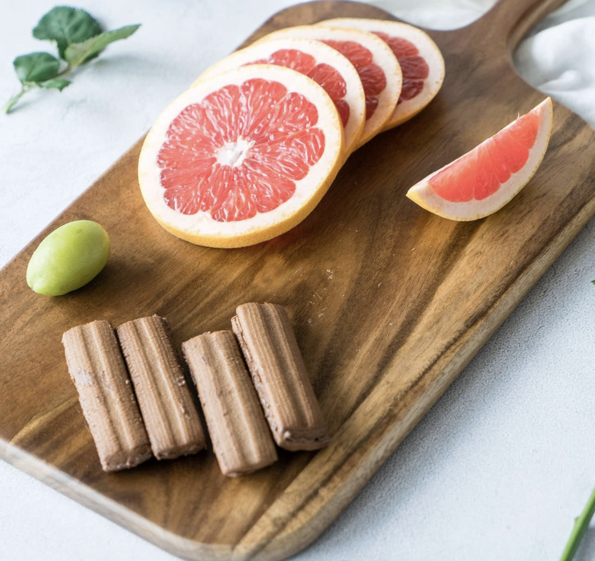 Grapefruit, grapes and cookies styled on a wood platter for home entertaining.