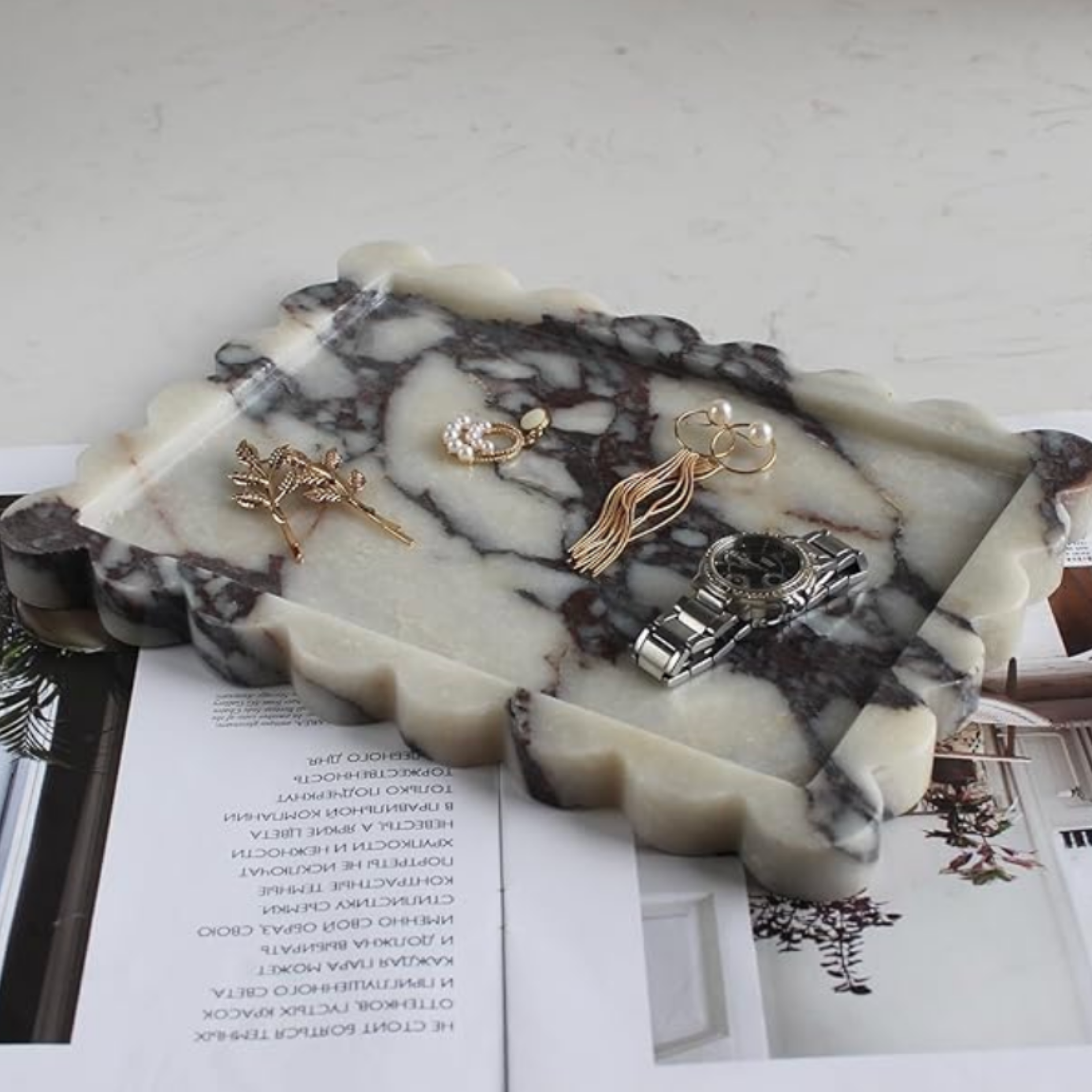 Curated gold jewelry and accessories styled on a marble surface for The G. Everett Edit.