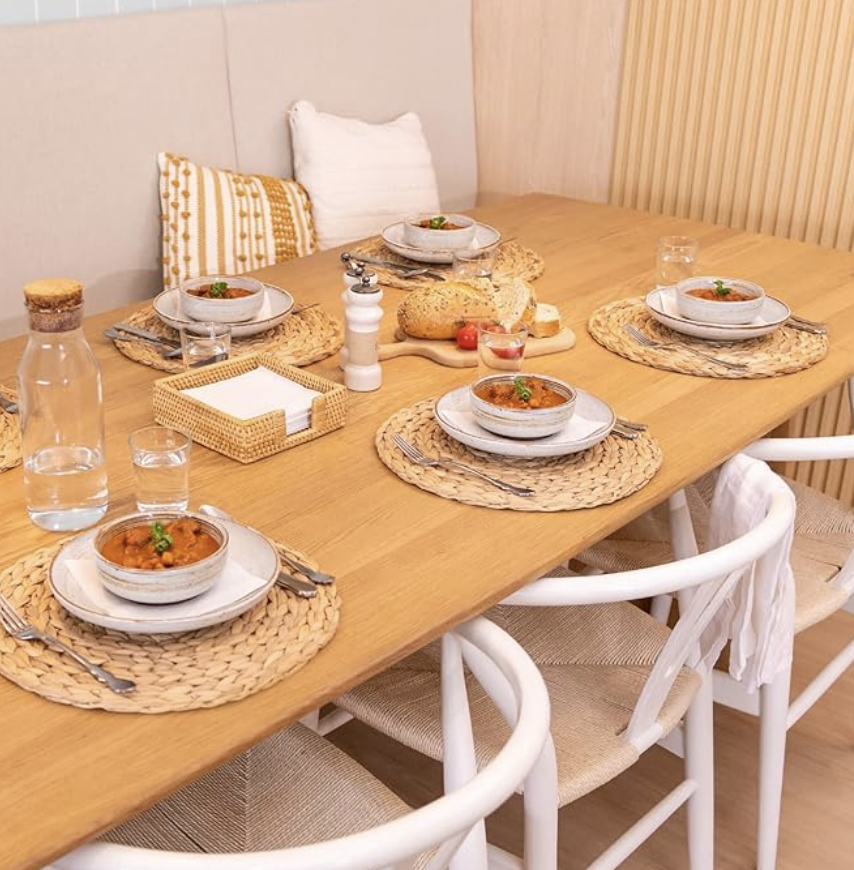 1. Wood dining table set for four with dinnerware, woven placemats and casual entertaining details.