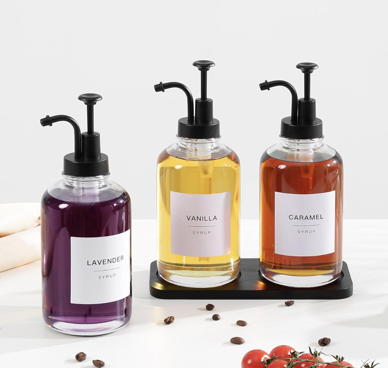 Glass flavored syrup bottles with pumps for a styled home coffee bar.