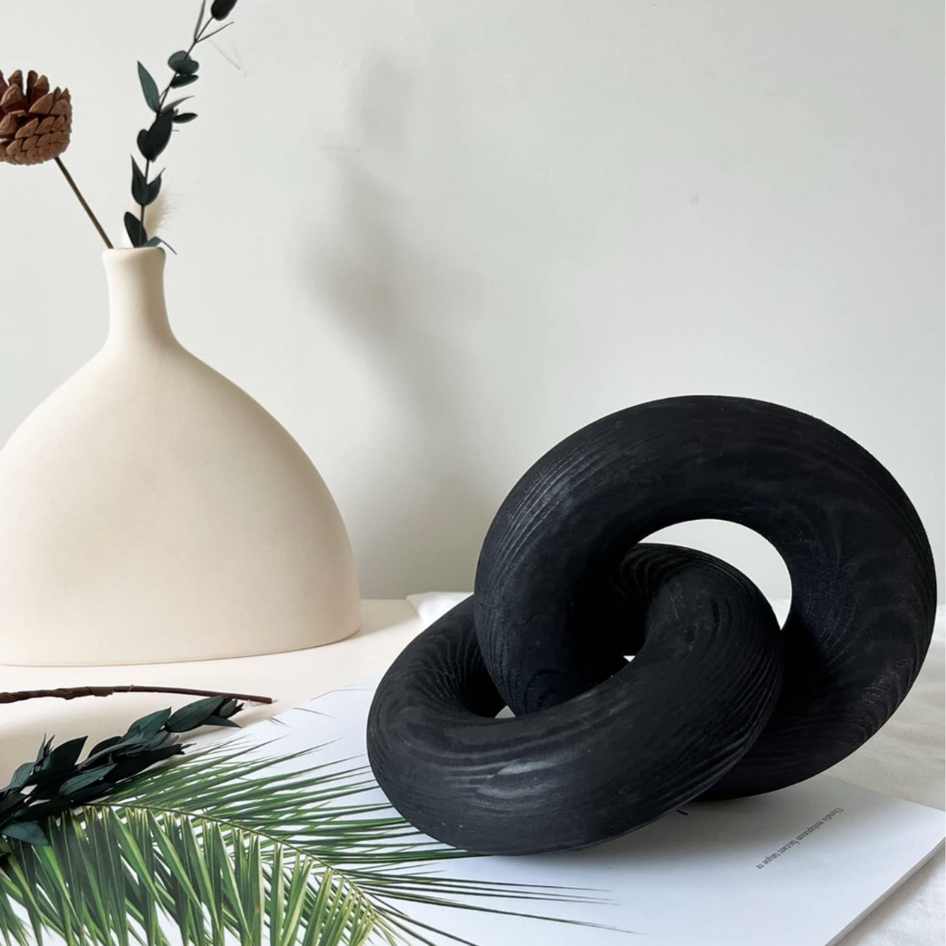 Minimalist white vase with dried botanical arrangement for curated home decor styling.