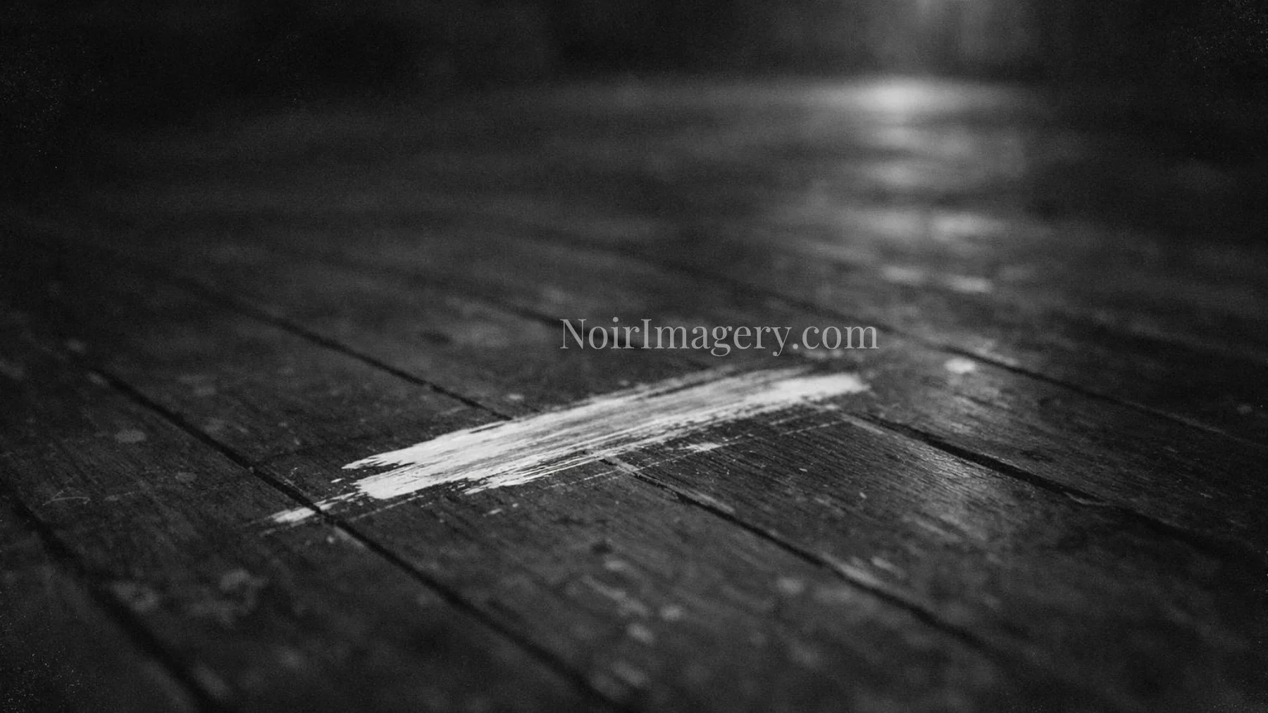 Black and white noir image of a paint smear streaked across a wooden floor.
