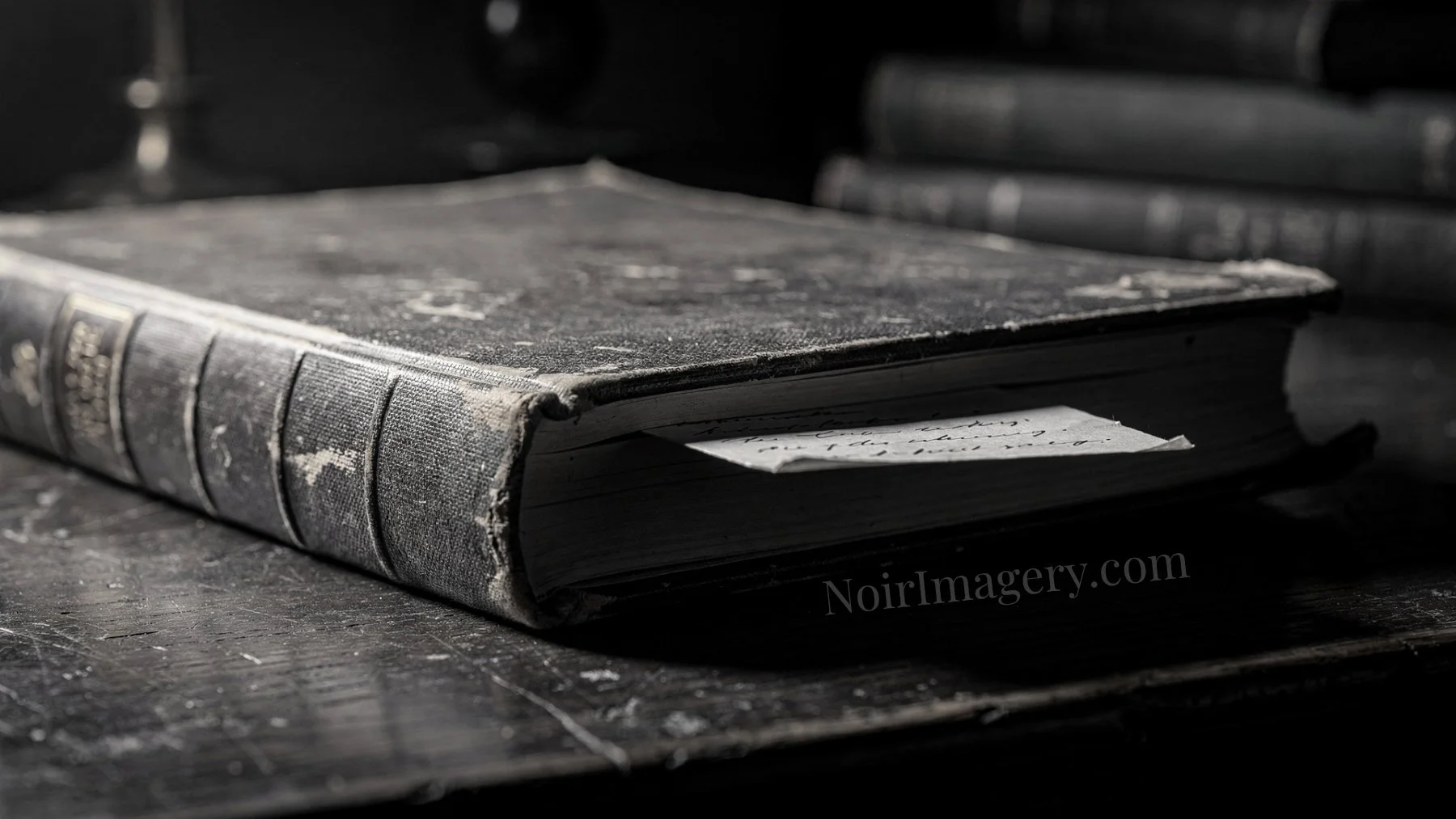 A folded handwritten letter tucked between the pages of an old book.