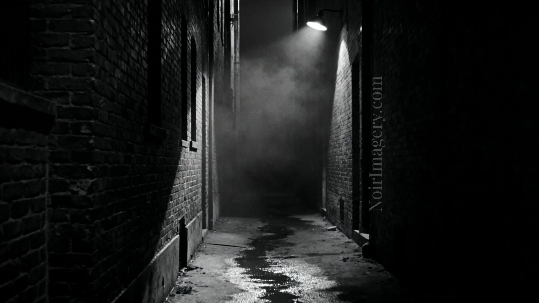 A narrow alley at night, it's unclear what lies in the dark.
