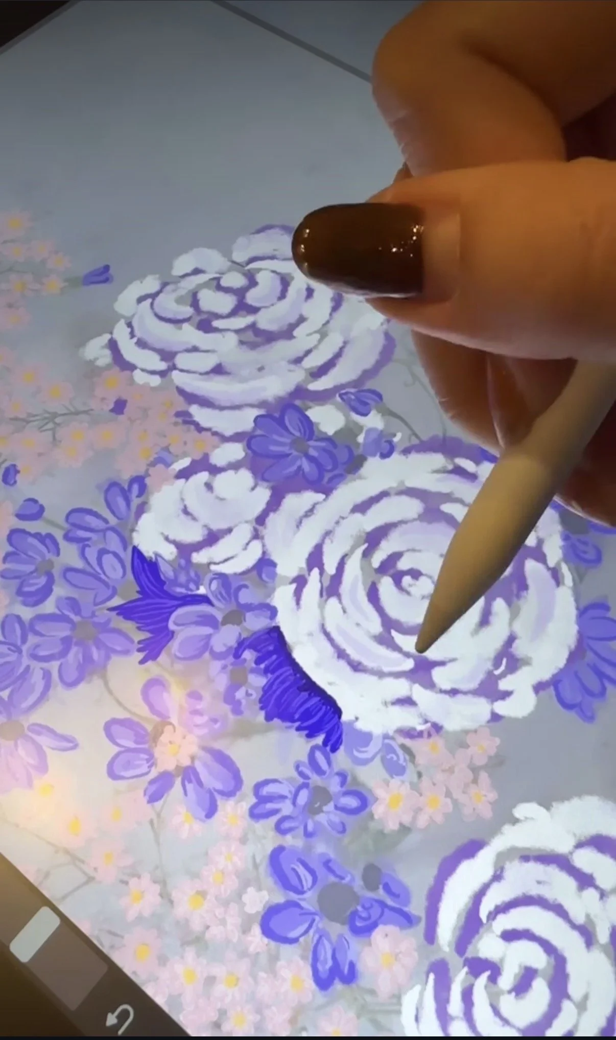 Digital artist drawing a floral pattern with a stylus on a tablet screen.