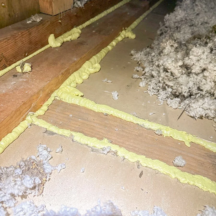 Close-up of foam sealant applied to the edges in an attic before installing insulation.
