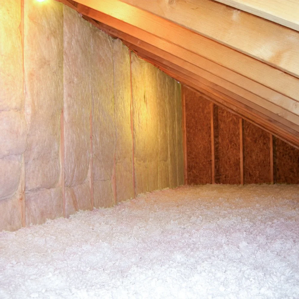 Attic space with insulated knee walls and blown-in fiberglass on the ceiling.
