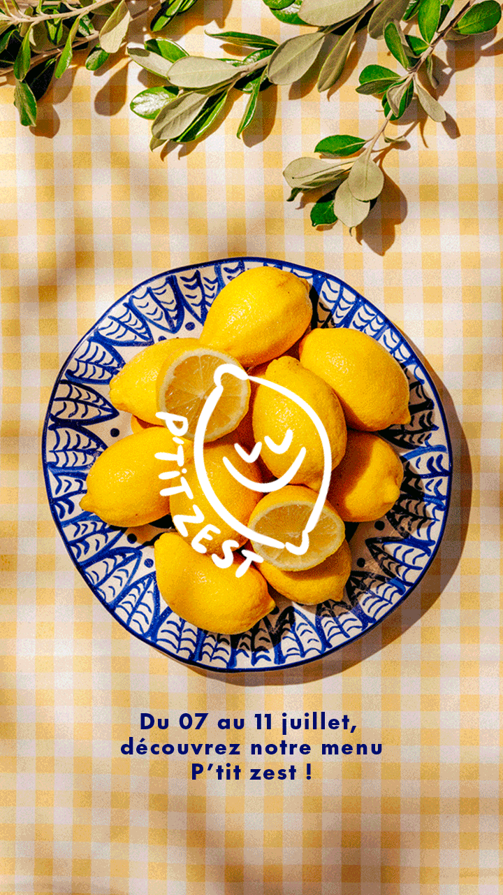 Un plat de citrons jaunes sur une assiette en céramique, avec un fond à carreaux orange et blanc, des branches de feuilles vertes en haut