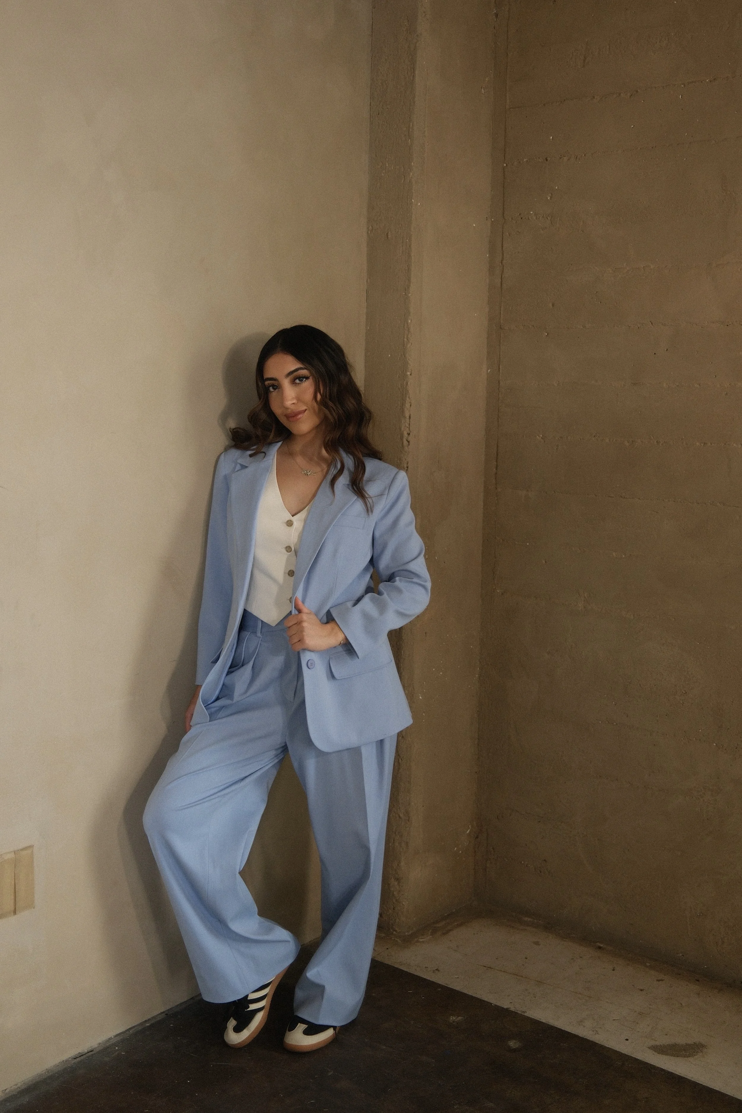 Dr. Sophia Chichyan, founder and lead chiropractor of Adjust + Align, standing in a light blue suit
