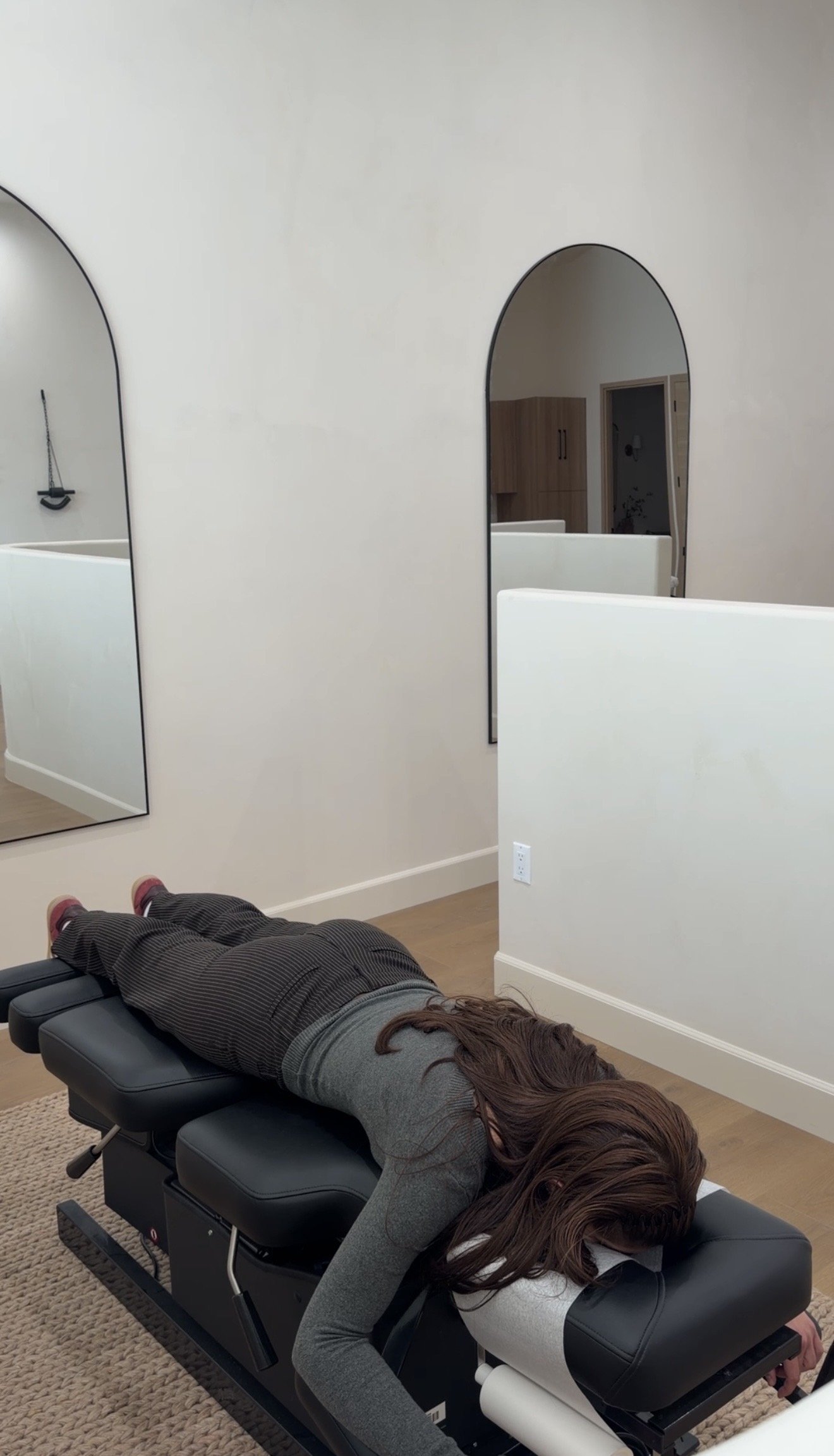 Person lying face down on a chiropractic treatment table at Adjust + Align