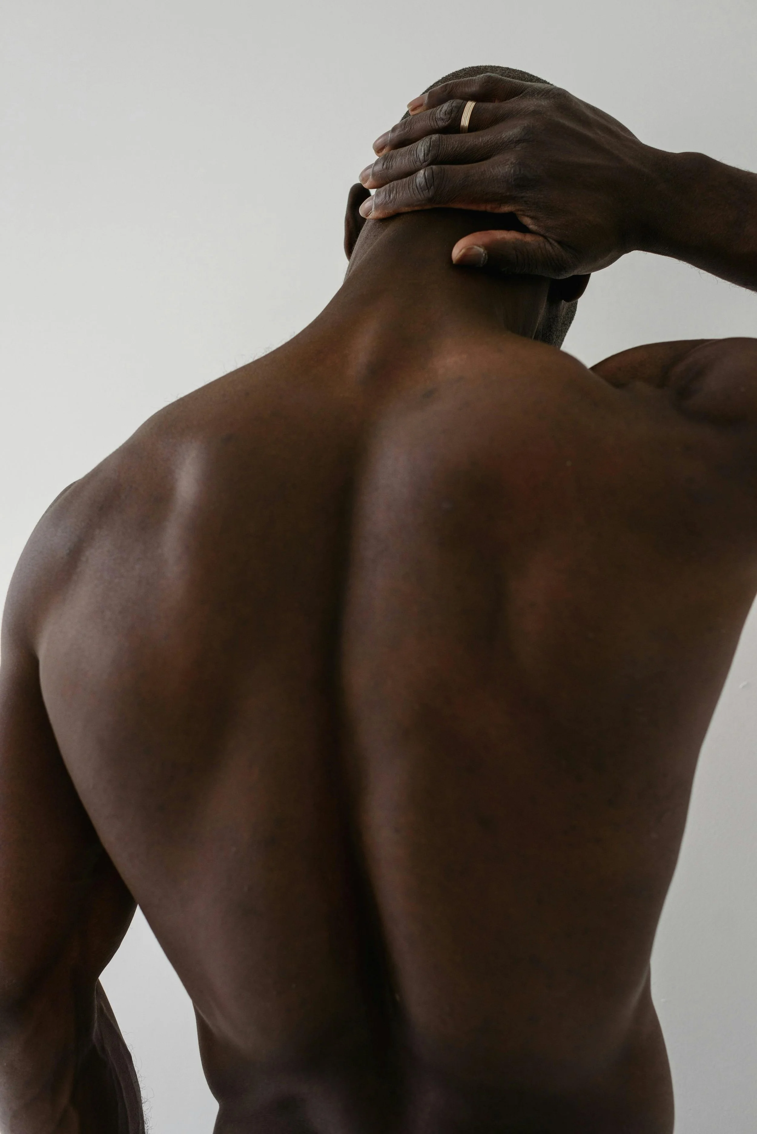 Man holding the back of his neck, representing body tension and chiropractic support