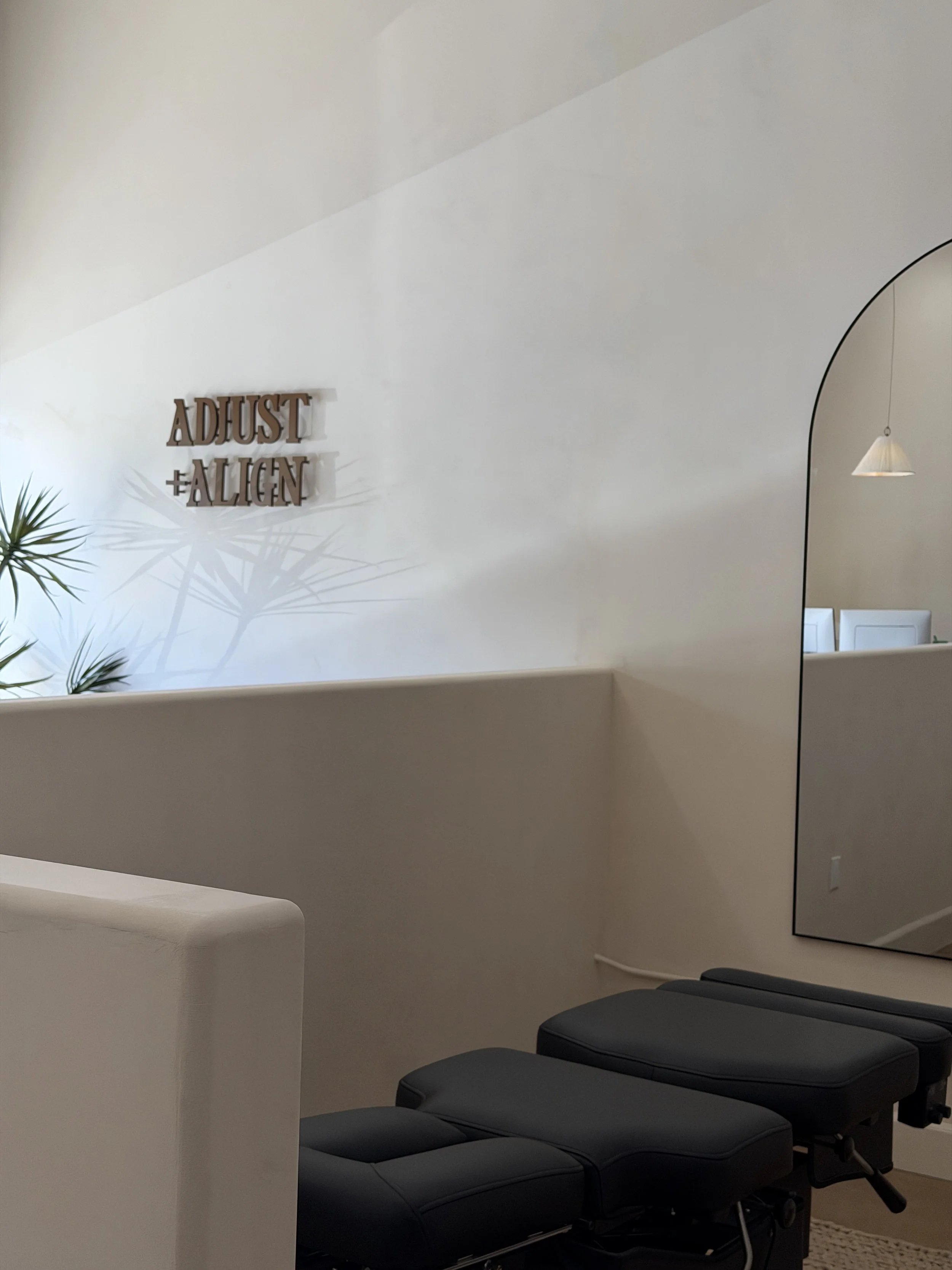 Black chiropractic treatment tables inside Adjust + Align’s Studio City office