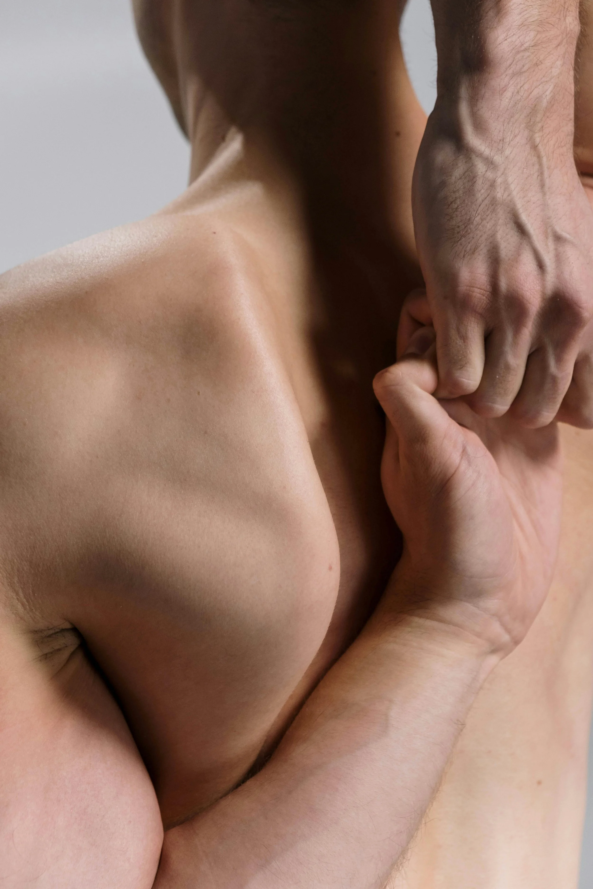 A man's hand stretching across his back to meet the other for a deep stretch, representing post-accident chiropractic care