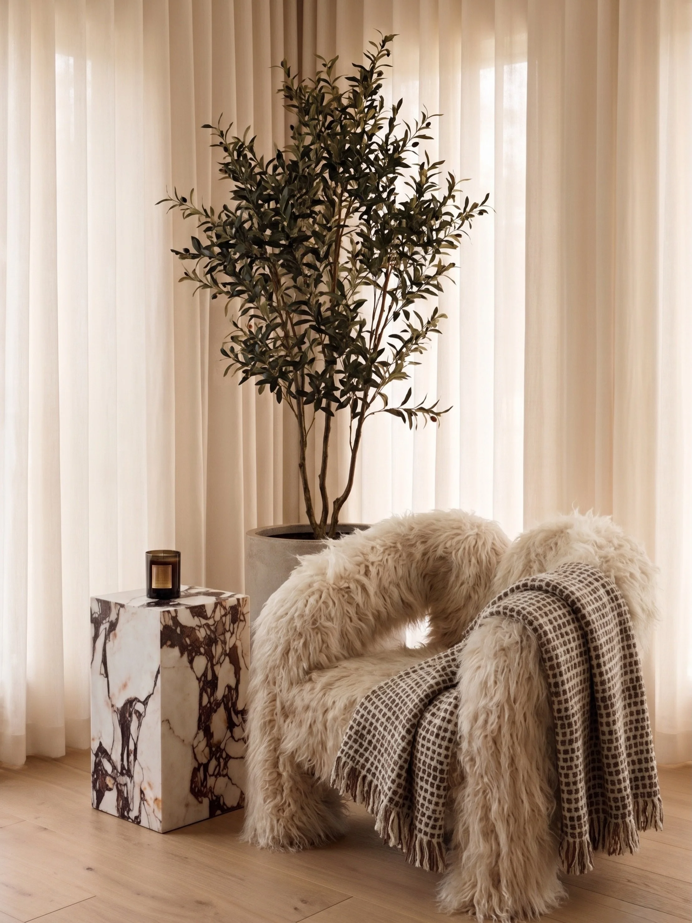 One piece can do more than fill a corner.

The chair here isn&rsquo;t just a seat &mdash; it&rsquo;s the point from which everything else finds its place. The marble plinth, the olive tree, the fall of the linen. Each element earns its position becau