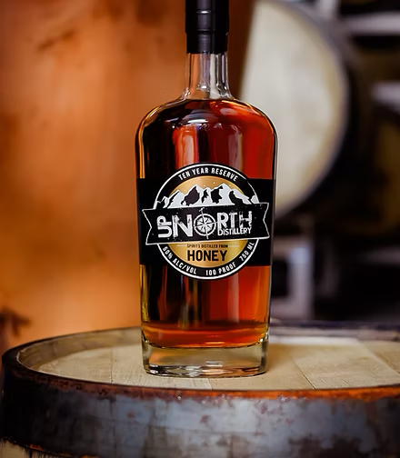 A bottle of North Disillery honey reserve whiskey on a wooden surface.