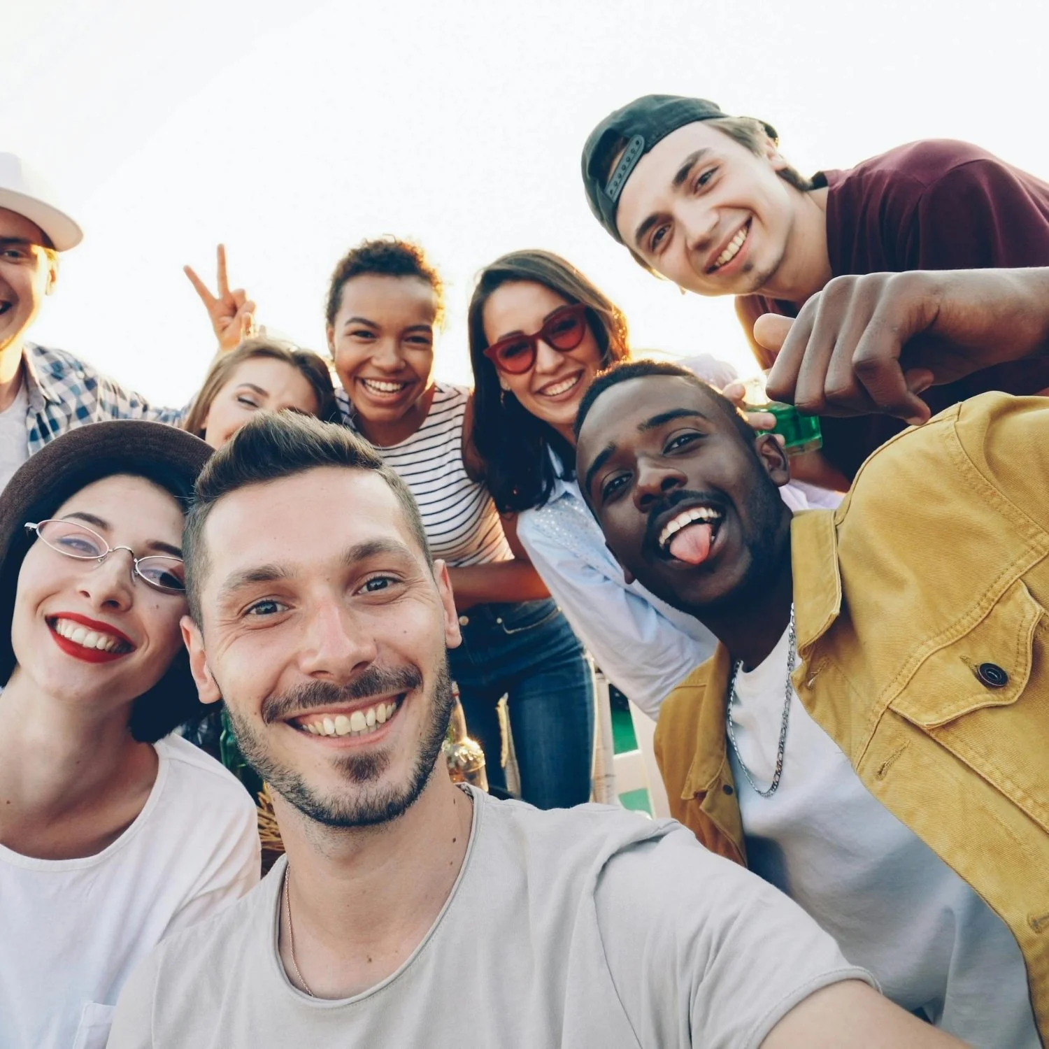 Group of friends taking a selfie outdoors, smiling and having fun.