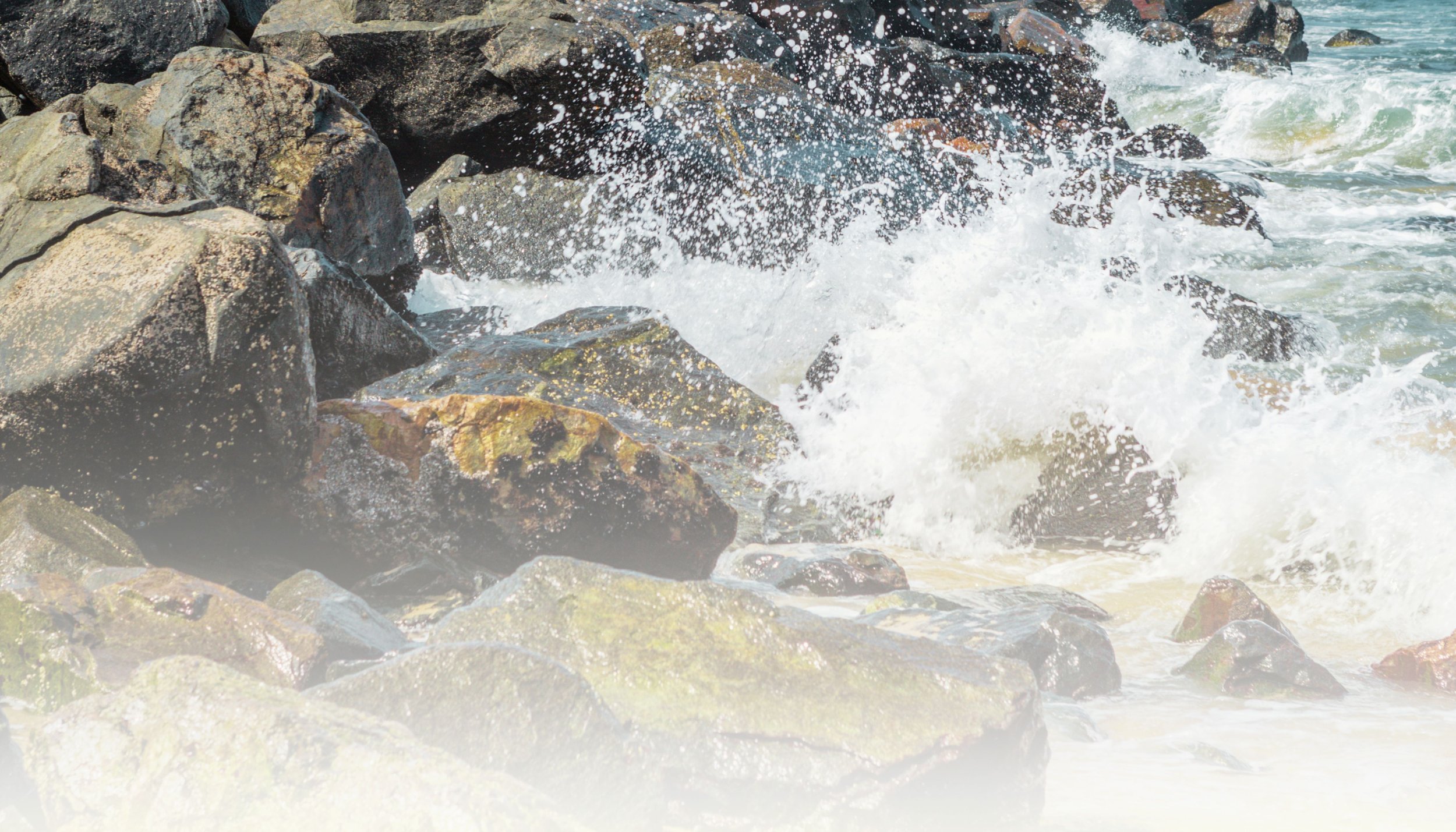 Waves crashing against rocks at the shoreline.