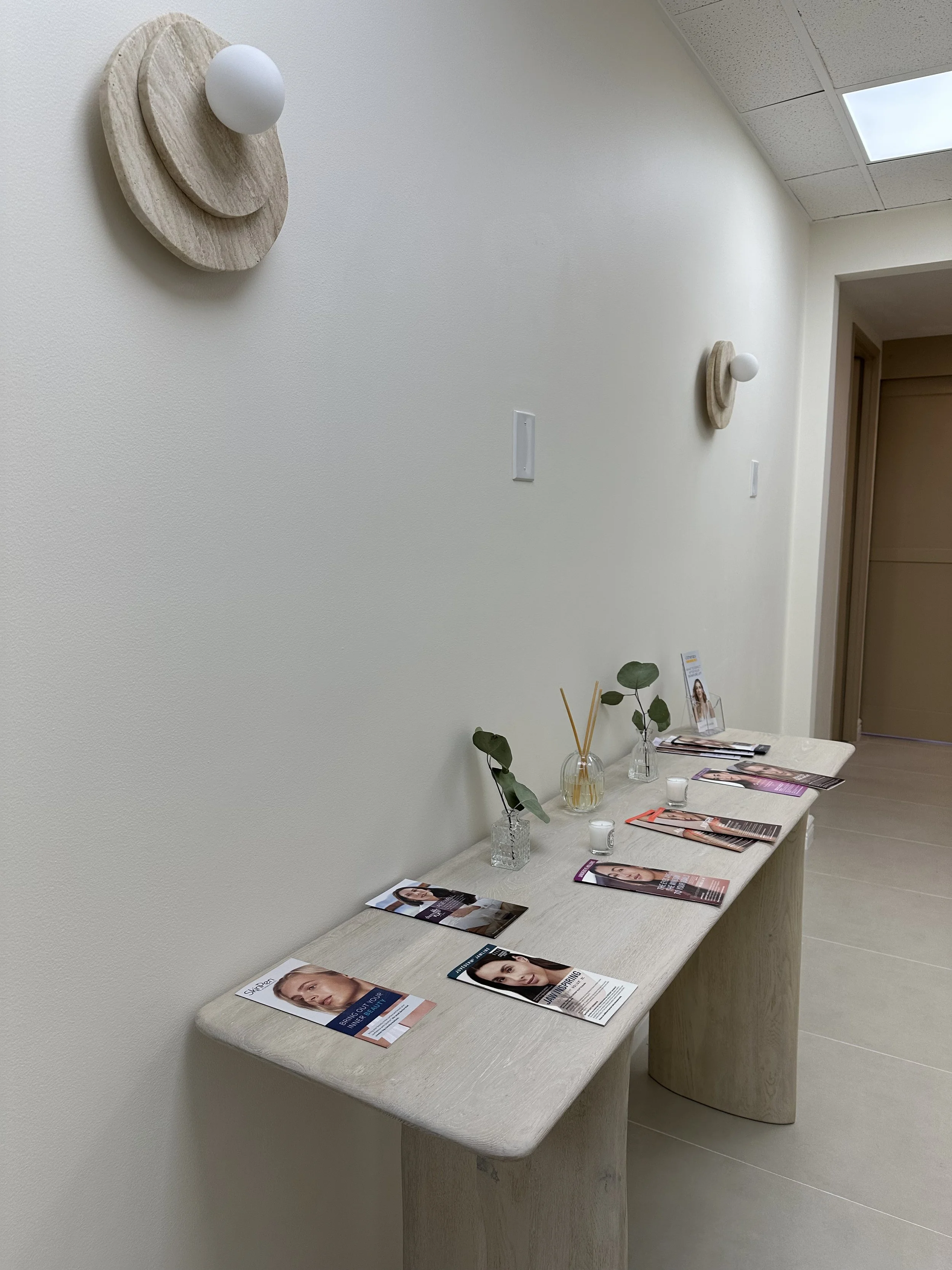VIQI Med Spa interior with stone wall lights, a display table and greenery