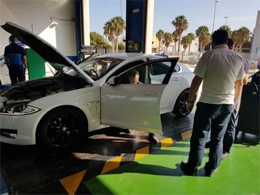 Jaguar XF Coupe is being inspected at the start of it's import test in Murcia Region as two of the ITV bosses look on. The test engineers are checking the vehicle identiication and data plates to ensure the vehicle conforms to it's original specifica