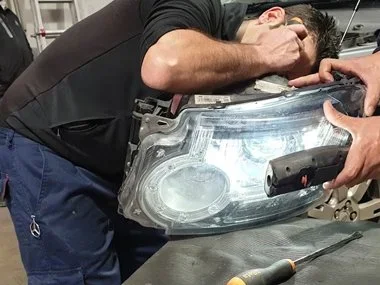 One of our workshop mechanics inspects headlight unit from Landrover Discovery. Our customer had paid a Landrover dealer for the headlights to be adjusted in the UK before he left, but they hadn't in fact been adjusted at all and had actually been br