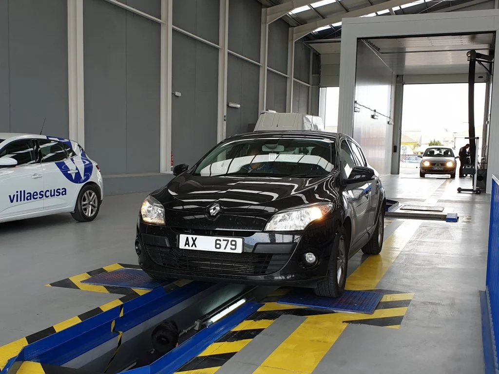 Renault Megane on UK plates is parked over inspection pit so that the suspension and underbody can be inspected. This is standard procedure during import testing as brakes and suspension elements are checked by ITV technical inspectors. This vehicle 