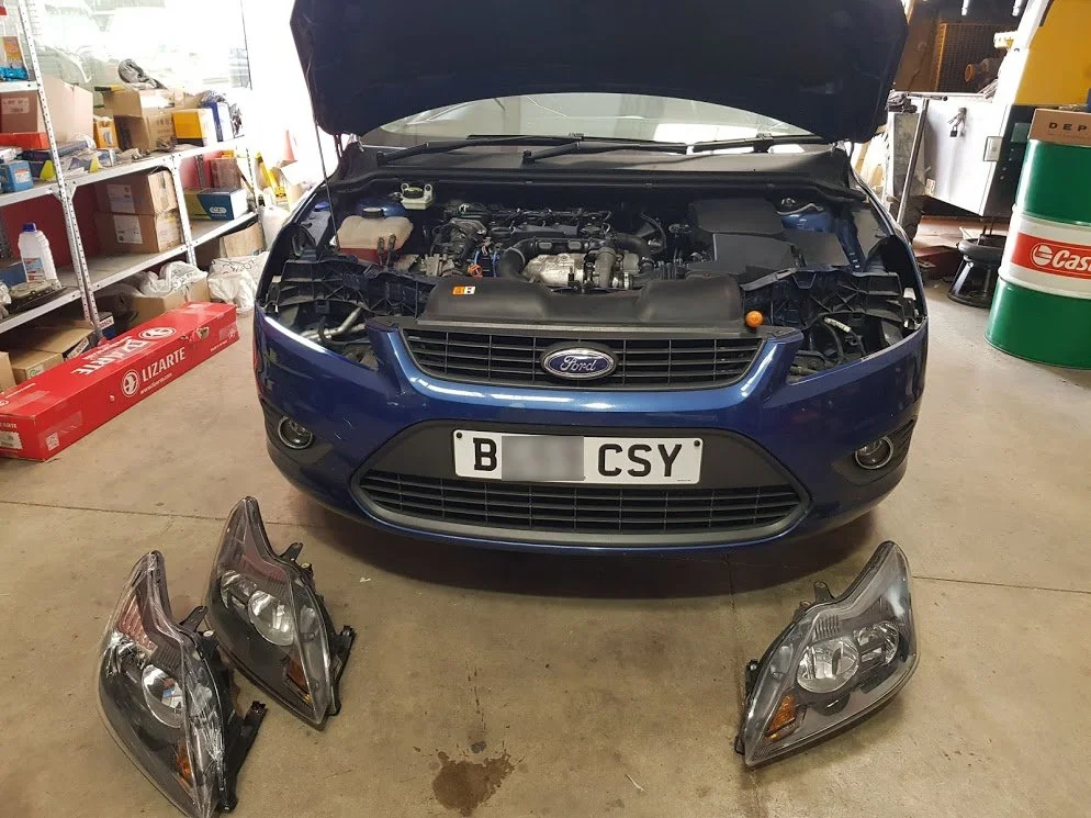 Ford Focus with headlights removed at our workshop in Murcia. We'll clean, check, change and replace headlamp and indicator bulbs before refitting and aligning the lights to ensure they are perfect for ITV import test - August 2018