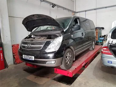 Hyundai i800 people carrier from Malaga region on elevator ramp at our workshop, about to have headlights changed for driving on right hand side of road - August 2018