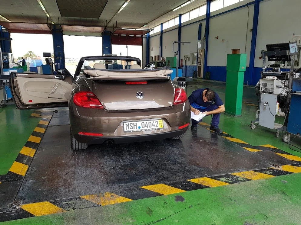 Volkswagen Beetle on weigh scale whilst ITV import technician makes a note of the tyre sizes to ensure compliance with the both Spanish and European regulations.  The vehicle had just arrived from Germany the day before - August 2018