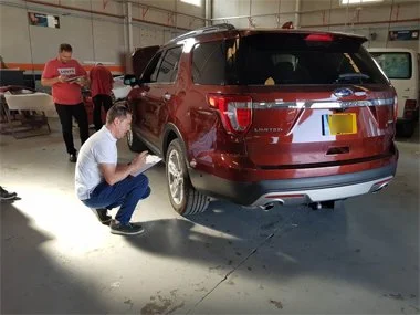 Ford Explorer SUV originally from USA but now registered on UK plates is inspected by two engineers at a workshop in Alicante area at the start of it's Individual Homologation test. This test is required because the vehicle does not have European Typ