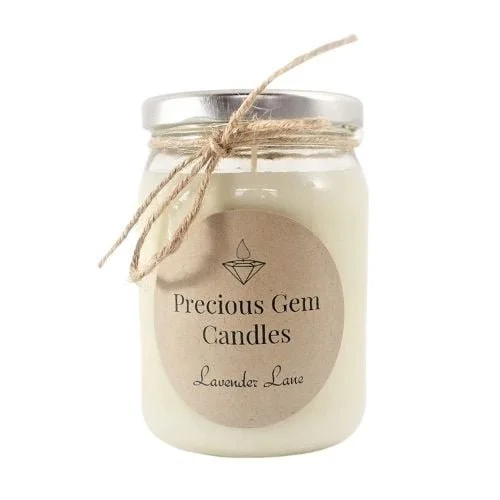 A white candle in a glass jar labeled 'Precious Gem Candles, Lavender Lane' with a rustic twine bow around the jar's neck.