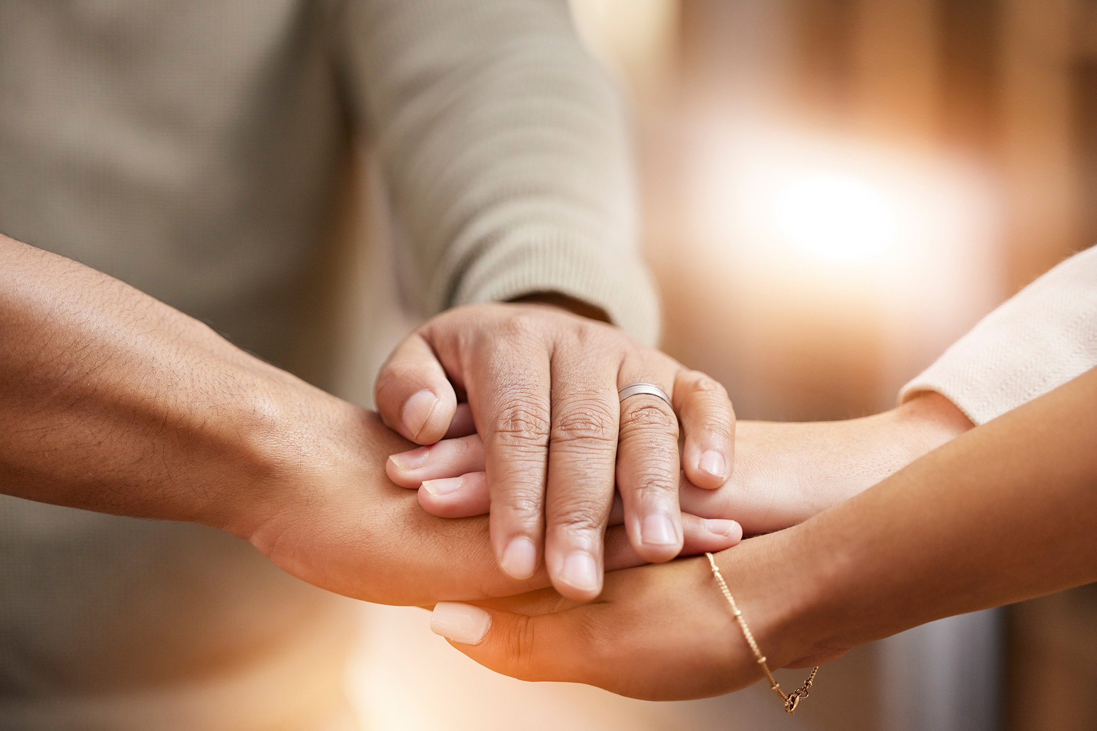 Close-up of three hands on top of each other.