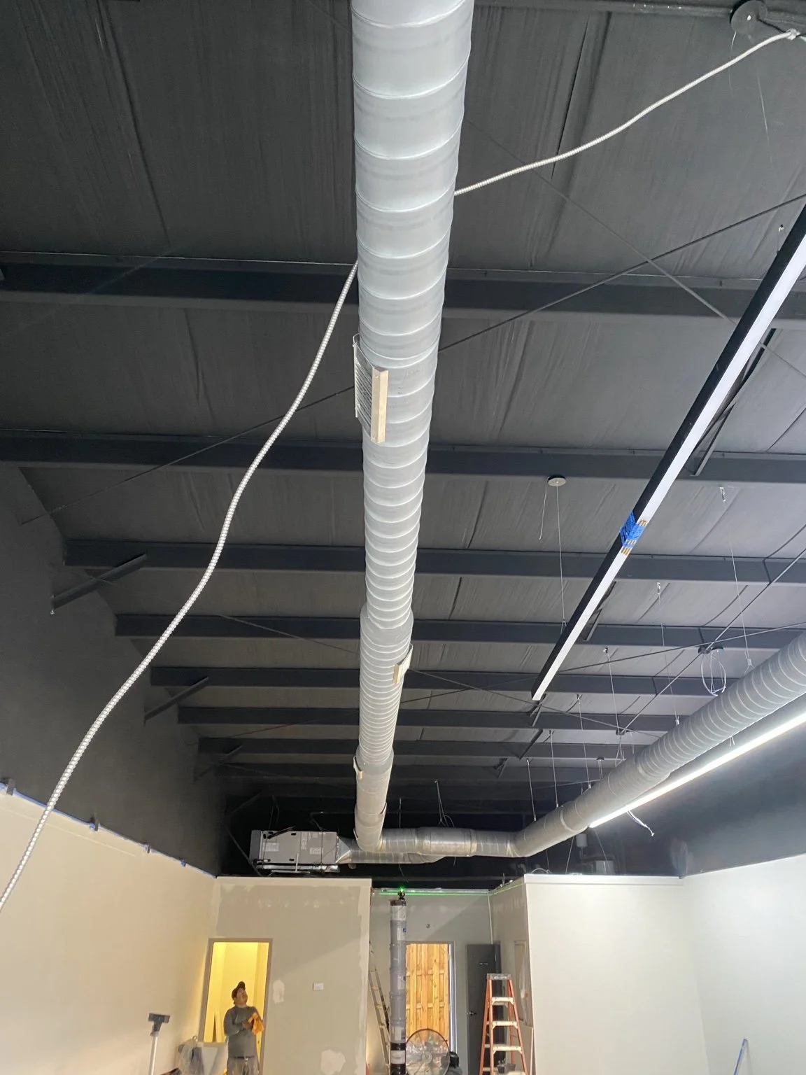Exposed spiral ductwork installed in a commercial space.