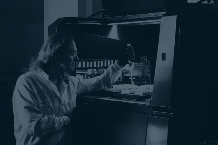 An investigator using a pipette in a crime lab.