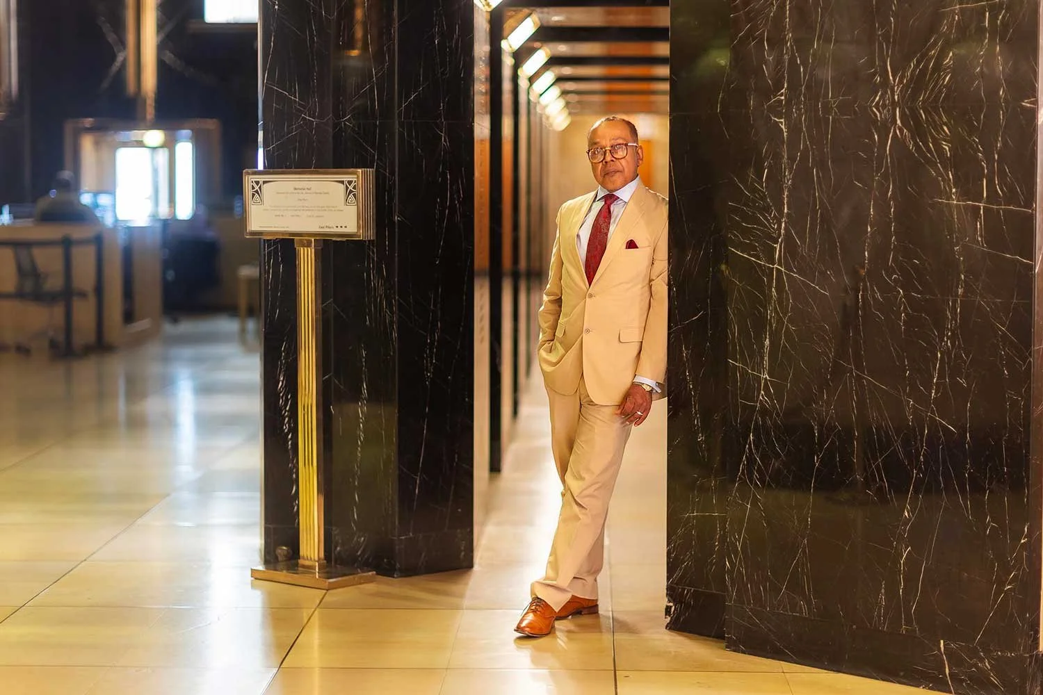 Attorney Thomas Harmon wearing a tan suit and standing near the Ramsey County Courthouse lobby.
