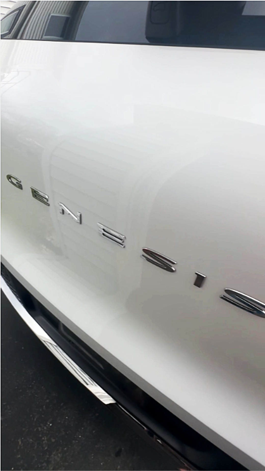 Close-up of a white Chevrolet vehicle with chrome letters spelling "Chevrolet" on the side.