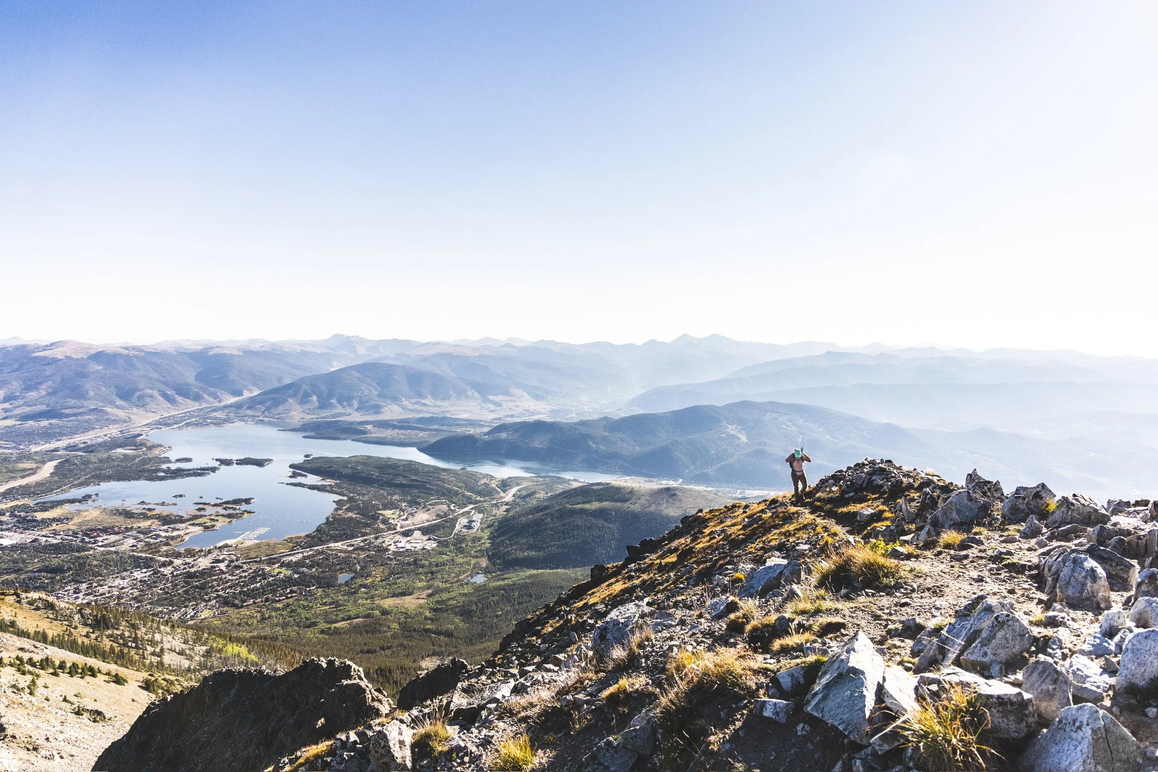 Caley Van Cleave, contemporary landscape painter, cresting the top of Peak One hike of the Ten Mile Range in Frisco, CO just after sunrise. Photo credit to Kevin Ingham. 