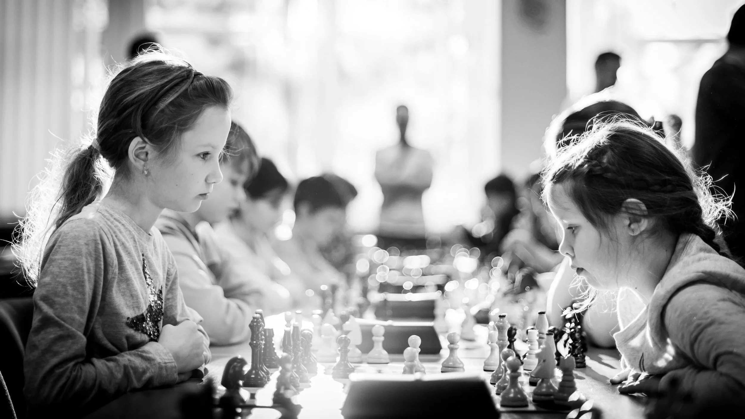 Two girls playing chess at a chess tournament