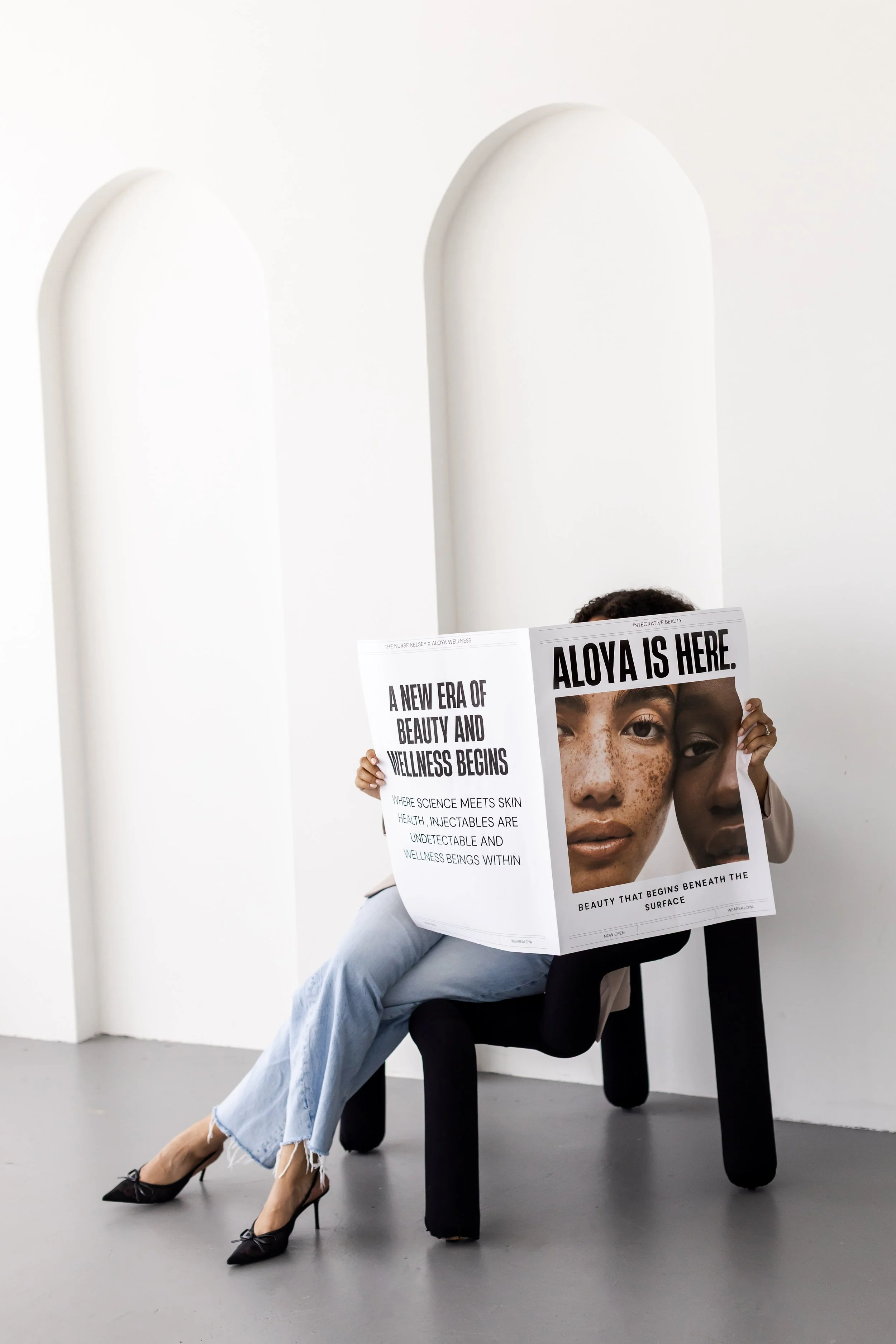 Branding photoshoot in Toronto for a beauty and wellness brand featuring model holding campaign poster in an editorial setting.