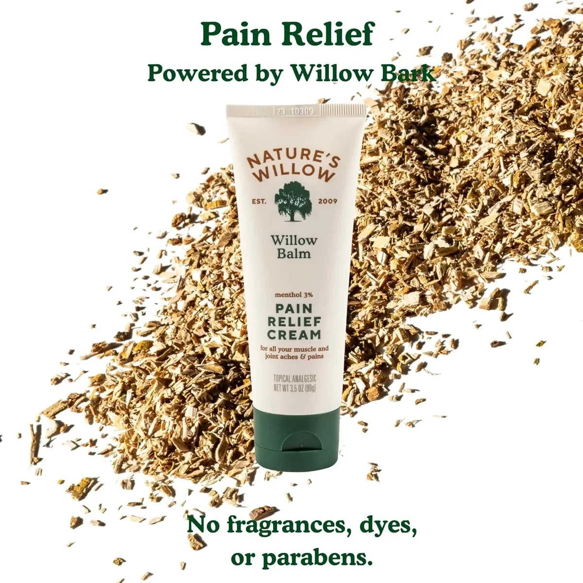 A tube of Nature's Willow Willows Balm Pain Relief Cream standing upright in front of a pile of wood chips. The text above the tube reads 'Pain Relief Powered by Willow Bark.' Additional text at the bottom states, 'No fragrances, dyes, or parabens.'