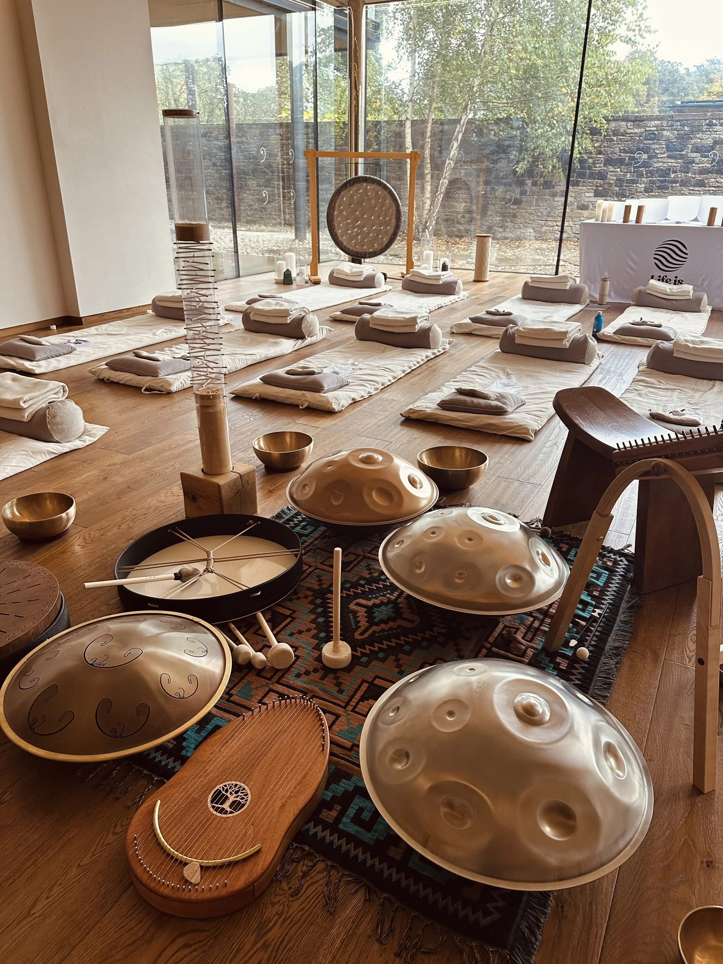 Life Is Sound Calm for Life wellness retreat at Broughton Sanctuary, Yorkshire, featuring a beautifully prepared sound bath space with crystal singing bowls, handpans, gong, relaxation mats and views of the surrounding nature.
