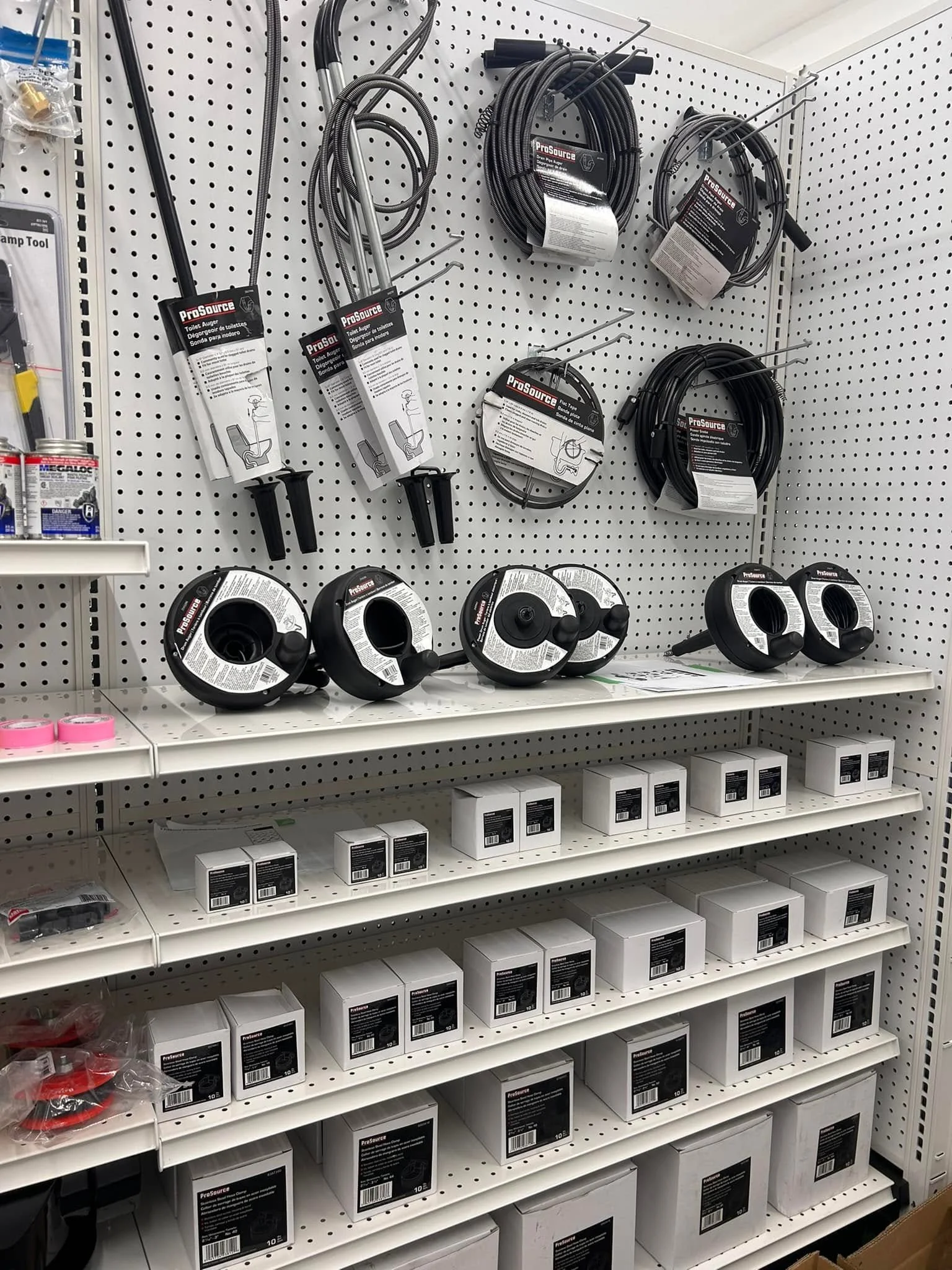A store pegboard displaying flex coils, cable spring and cable wire hook, organized and hung for sale.