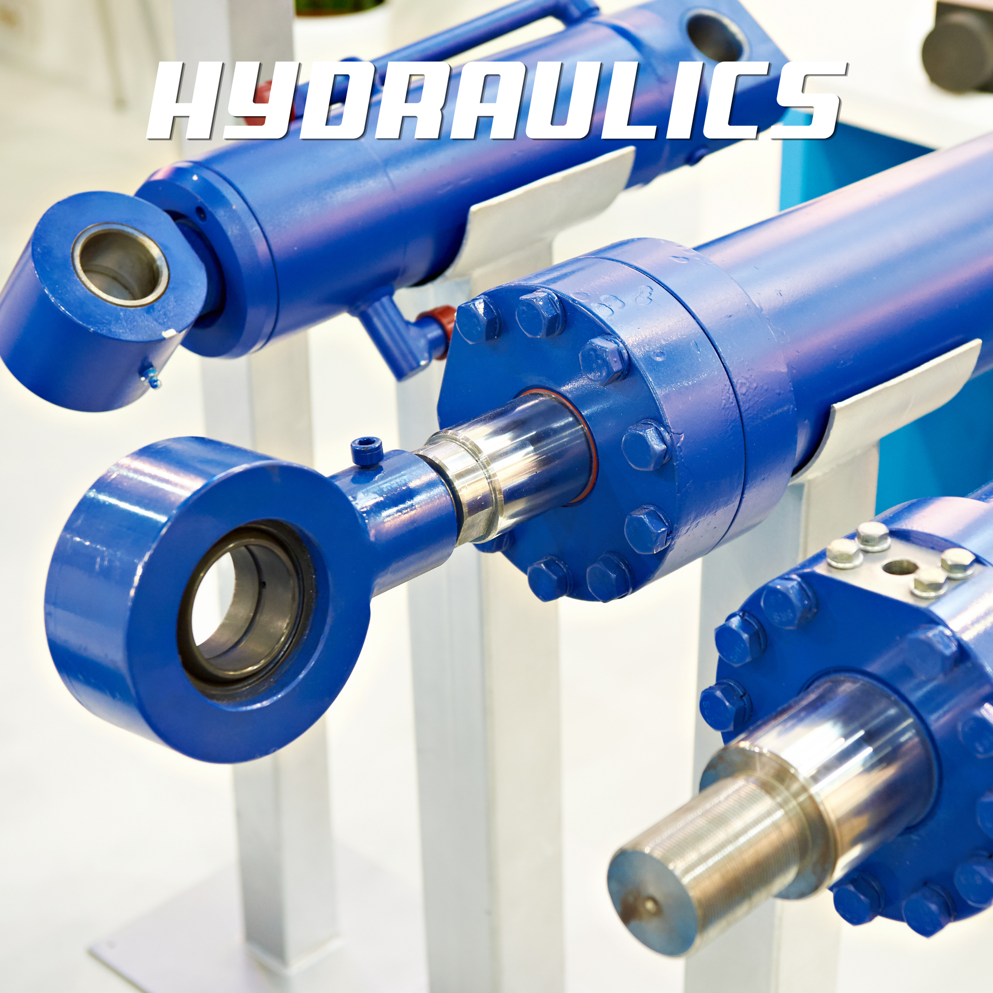 Close-up of industrial blue hydraulic cylinders with silver piston rods mounted on a machine.