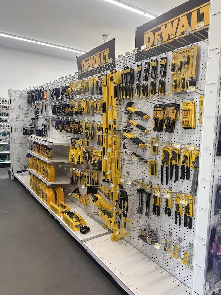 Display of Dewalt power tools and hand tools on store shelf.