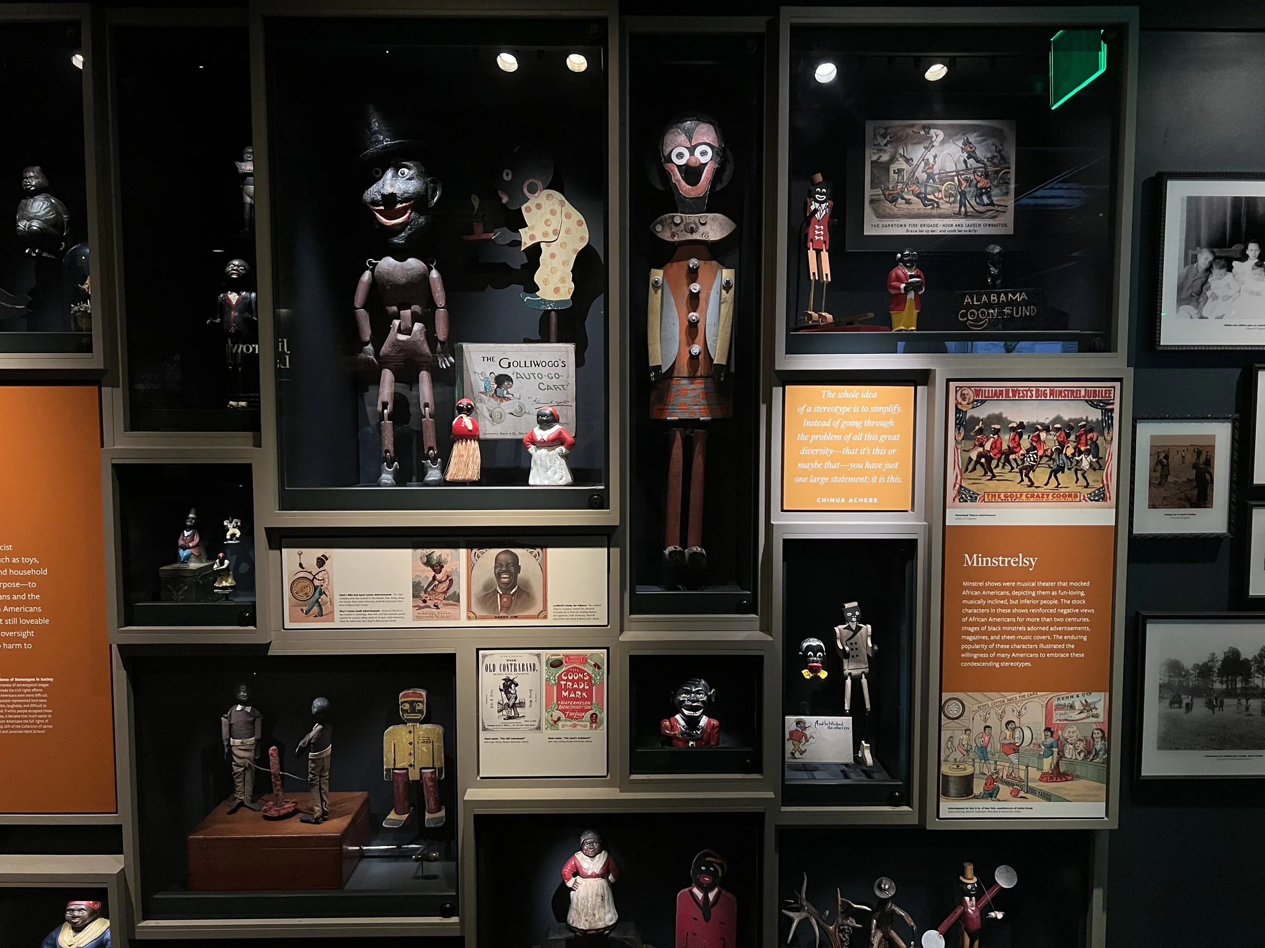 A display case showcasing various vintage and collectible puppets and figurines, along with informational signs about their history and cultural significance.