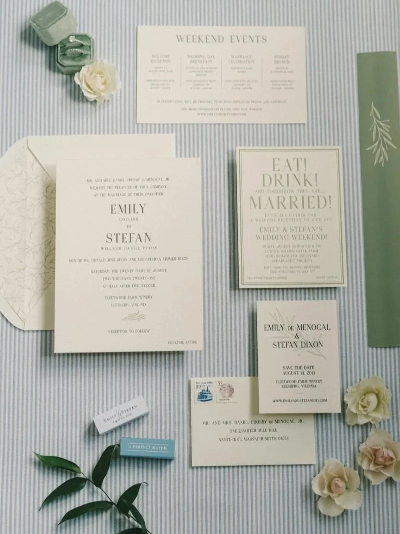 Wedding invitation suite with event details, save the date card, small envelope, vintage postage stamp, and floral decor on a striped fabric background.
