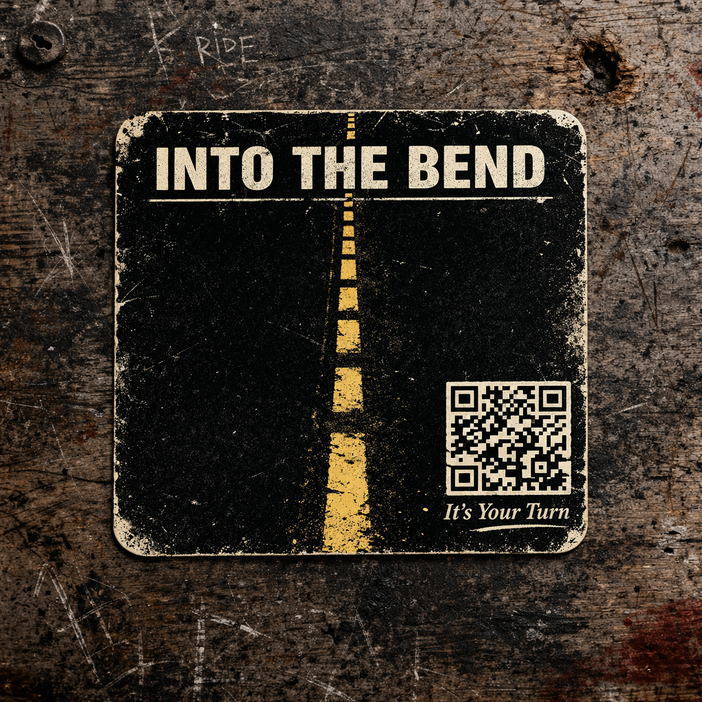 A worn black and white sign with yellow dashed lines resembling a road, displaying the text 'INTO THE BEND,' a QR code, and the phrase 'It's Your Turn' on a textured wooden surface.