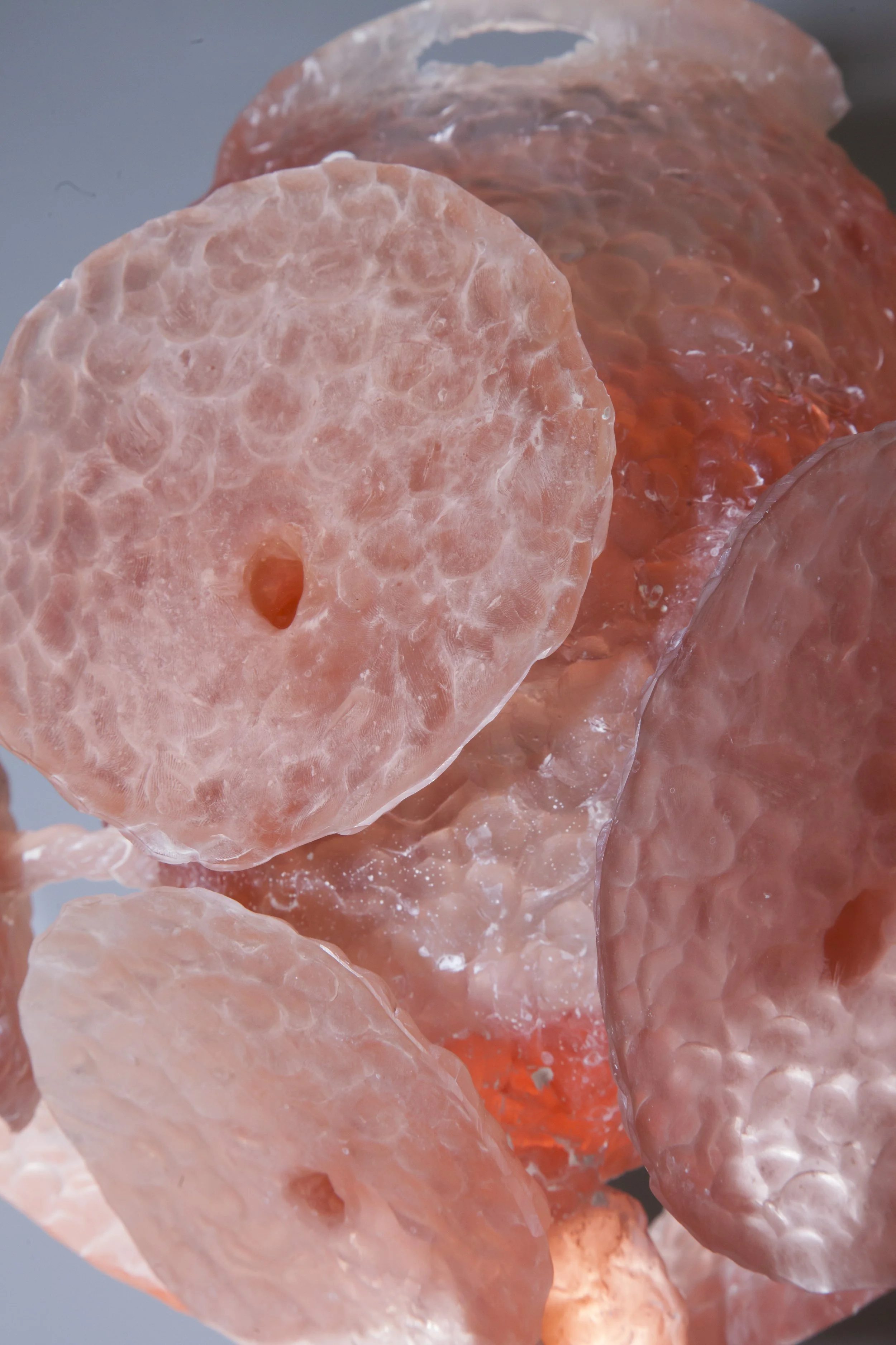 Close-up of pink Himalayan salt crystals with a textured surface and translucent appearance.