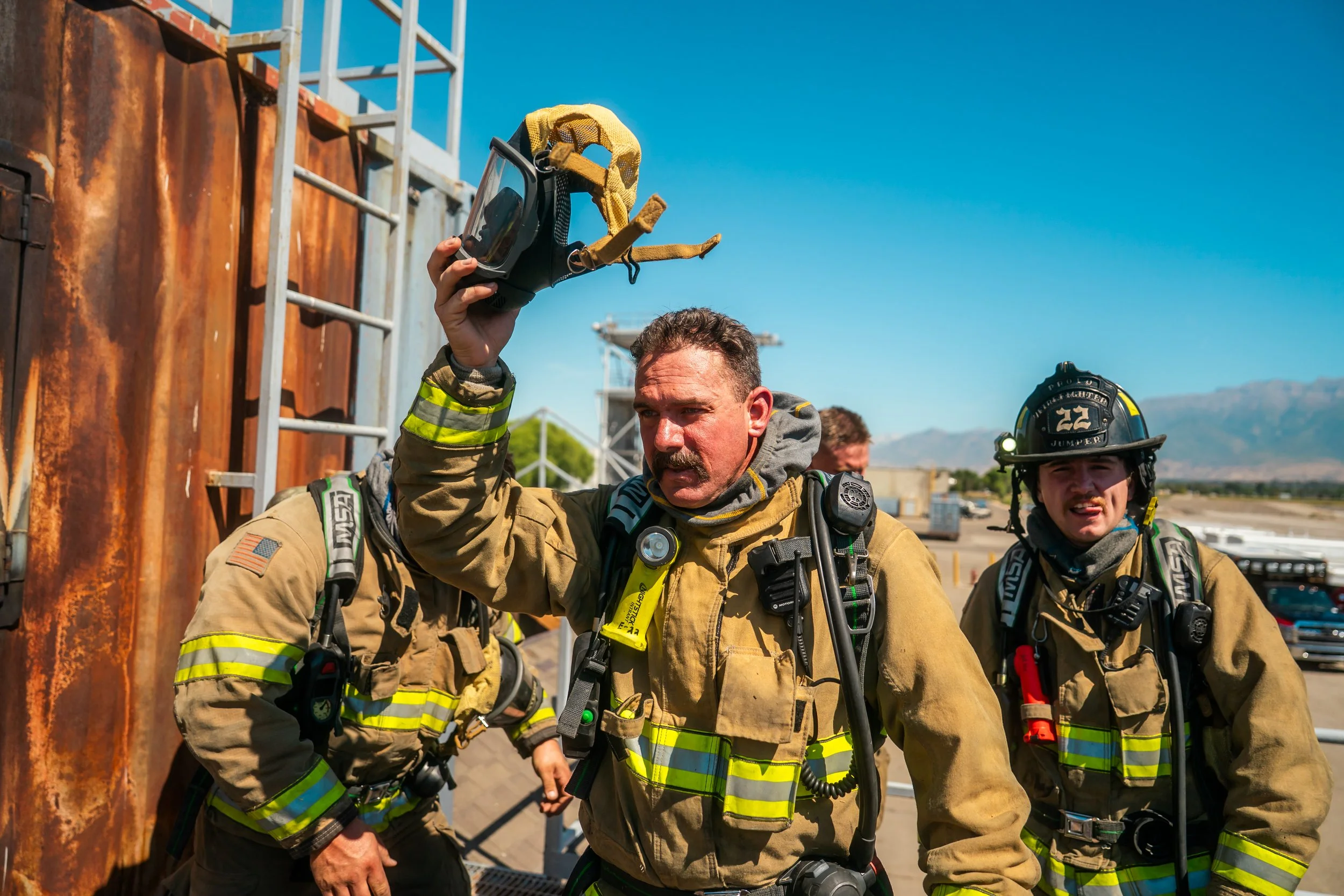 A firefighter takes off his respirator after a training scenario.