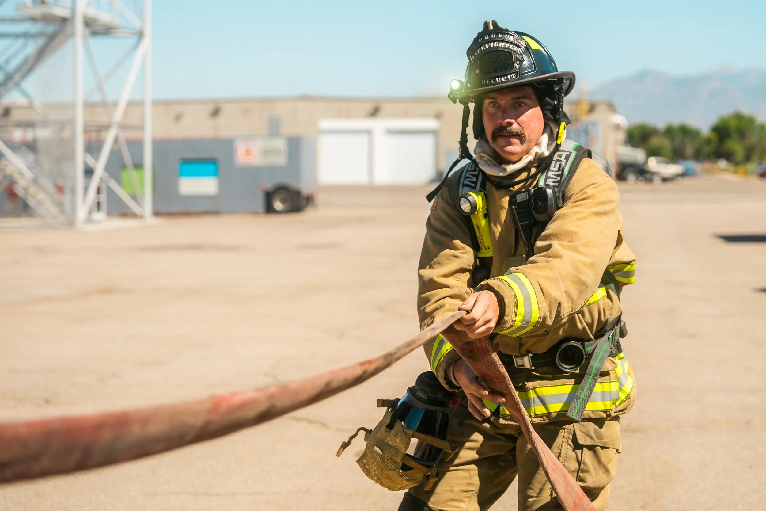 A firefighter pulls the hose at the beginning of a training.