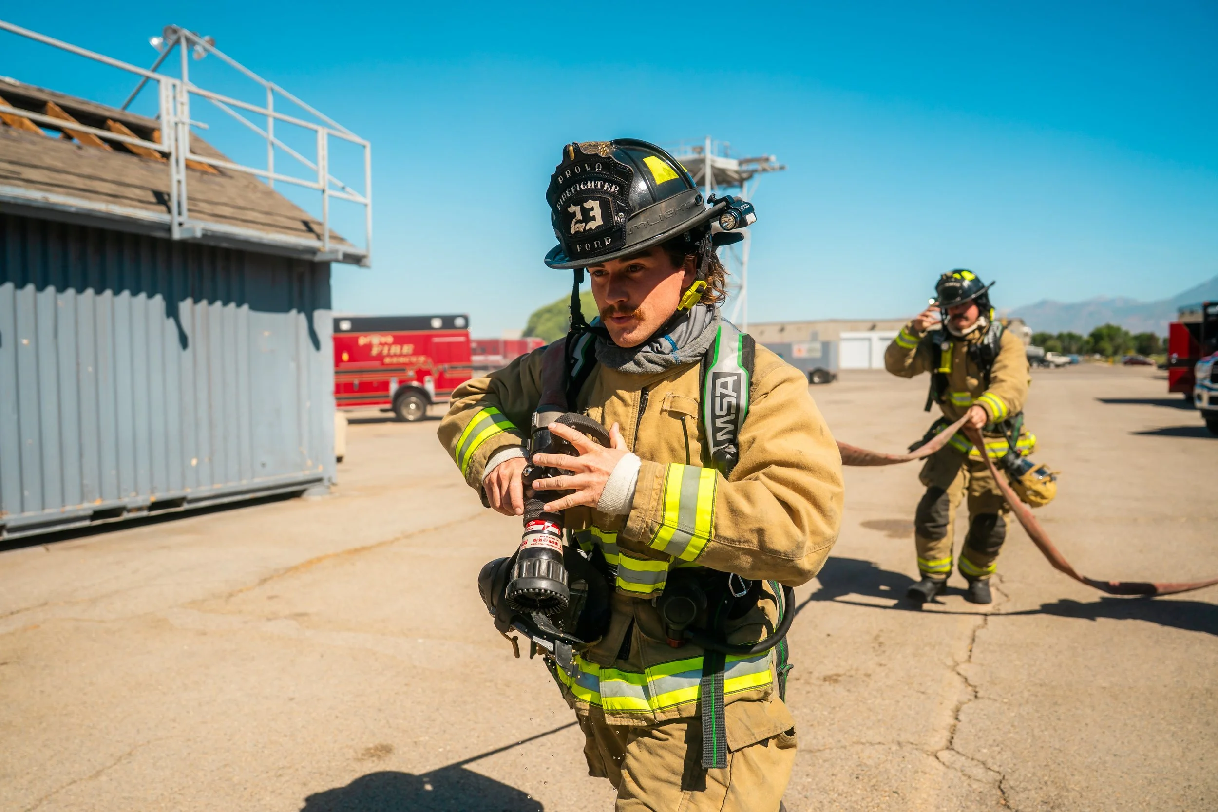 A firefighter starts a hose line during a training.